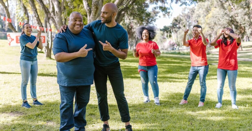 Group of adults engaging in fun team building activities in a sunny park, showcasing teamwork and diversity.